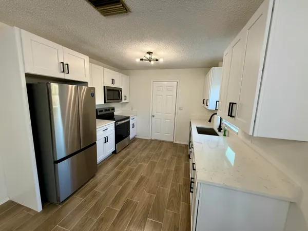 a kitchen with stainless steel appliances a refrigerator sink and microwave