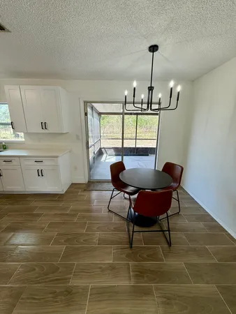 a kitchen with kitchen island granite countertop a dining table chairs and granite counter tops