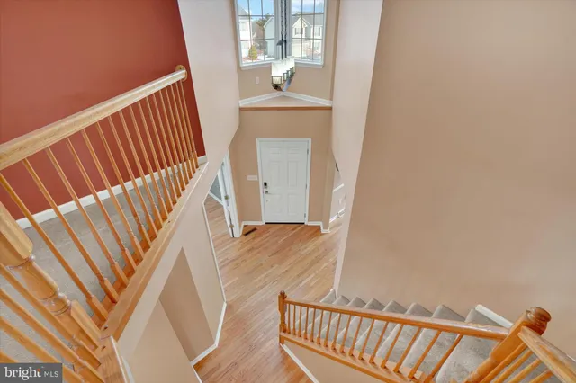 a view of a hallway with wooden floor and stairs