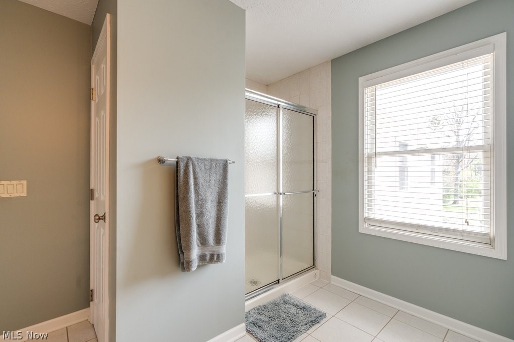 6325 Brecksville Road Independence, OH 44131 - Photo 34 of 50 Bathroom featuring a glass-enclosed shower, a window with blinds, and light-colored wall tiling