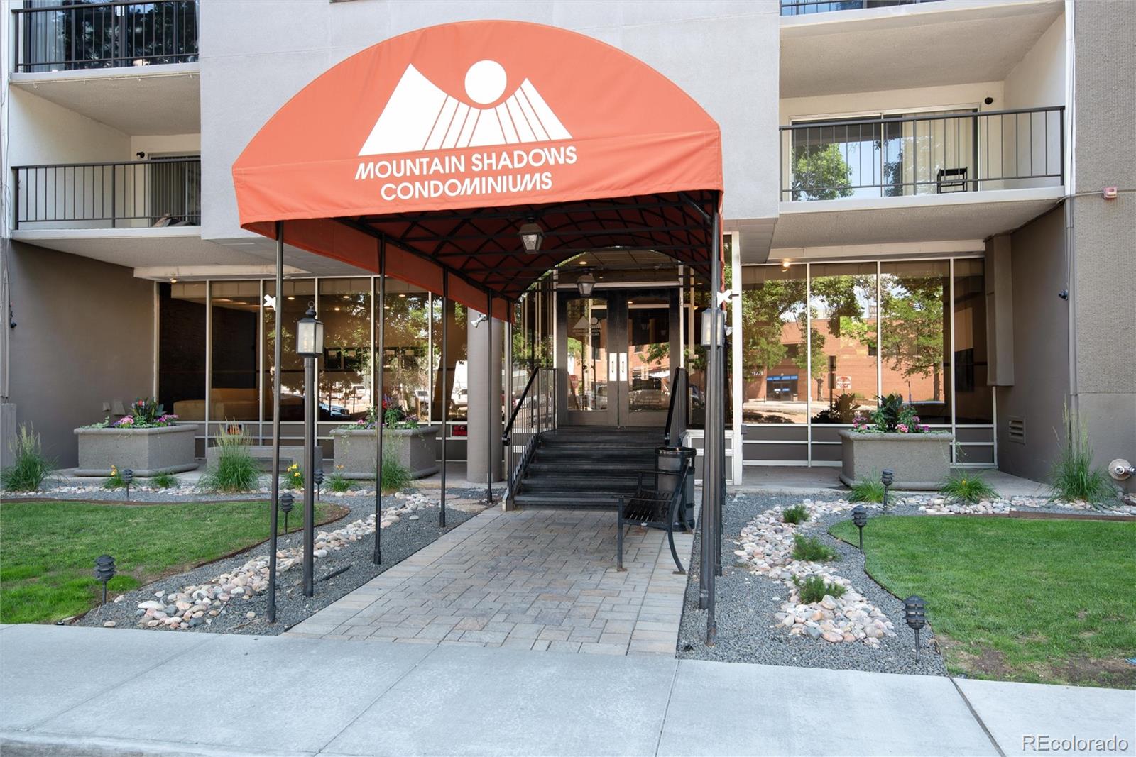 a view of a cafe with a table and chairs under an umbrella