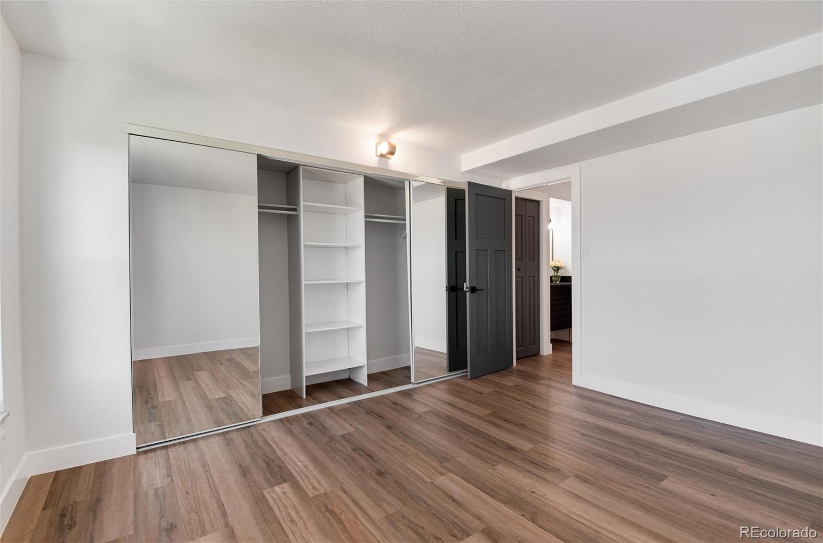 2 Adams Street, Unit 1504 Denver, CO 80206 - Photo 19 of 43 an empty room with wooden floor and closet