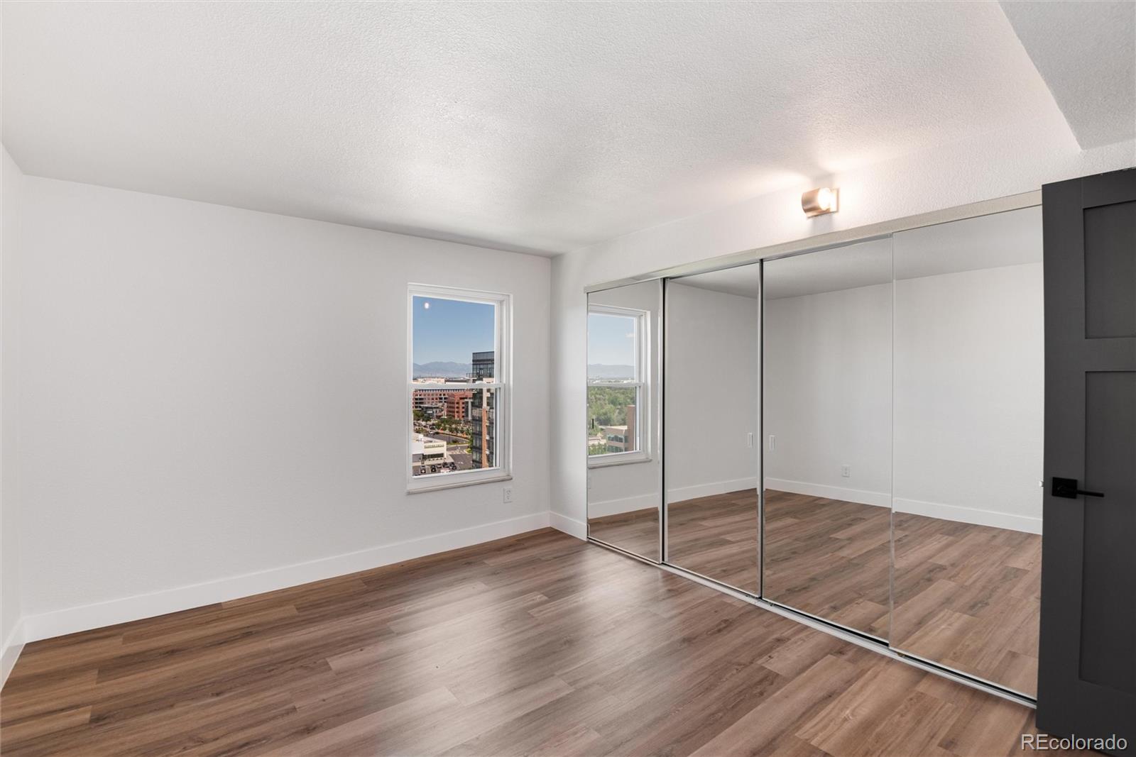2 Adams Street, Unit 1504 Denver, CO 80206 - Photo 20 of 43 a view of an empty room with wooden floor and a window