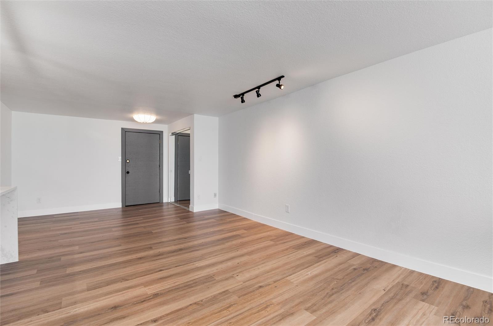 2 Adams Street, Unit 1504 Denver, CO 80206 - Photo 22 of 43 a view of an empty room with wooden floor and a ceiling fan