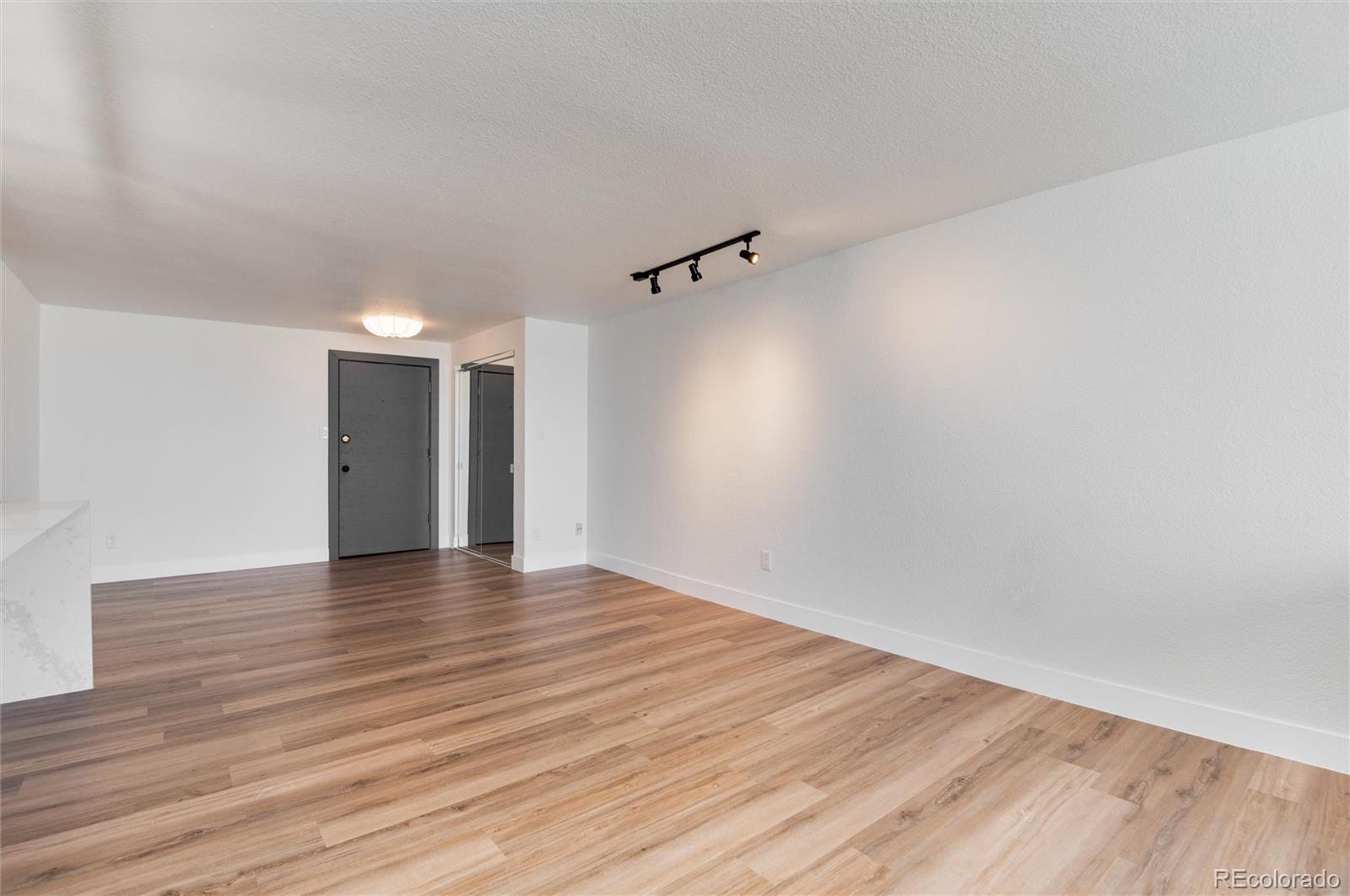 2 Adams Street, Unit 1504 Denver, CO 80206 - Photo 23 of 43 a view of an empty room with a window and wooden floor
