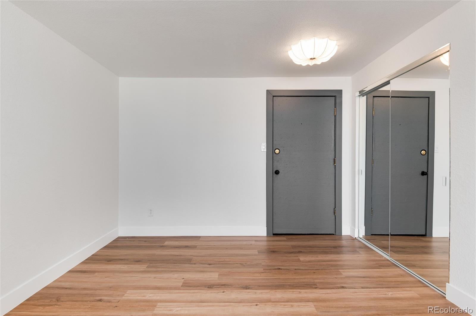 2 Adams Street, Unit 1504 Denver, CO 80206 - Photo 24 of 43 a view of an empty room with wooden floor and closet