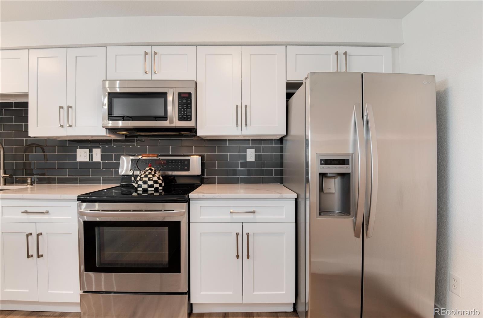 2 Adams Street, Unit 1504 Denver, CO 80206 - Photo 9 of 43 a kitchen with cabinets stainless steel appliances and a wooden floor