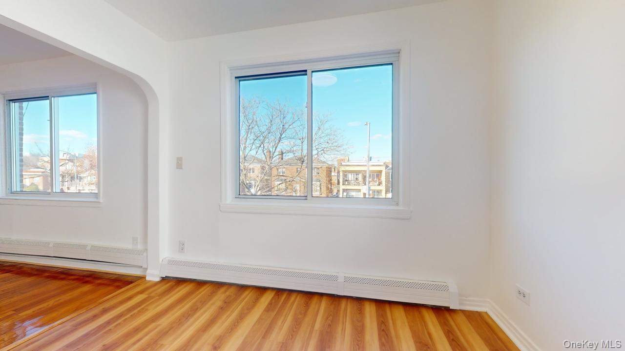 105-28 63rd Road, Unit 2 Queens, NY 11375 - Photo 11 of 30 a view of an empty room with wooden floor and a window