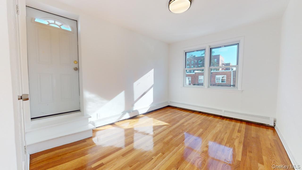 105-28 63rd Road, Unit 2 Queens, NY 11375 - Photo 22 of 30 a view of an empty room with wooden floor and a window