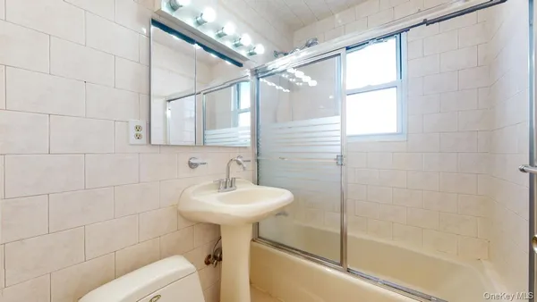 a bathroom with a sink mirror toilet and bathtub