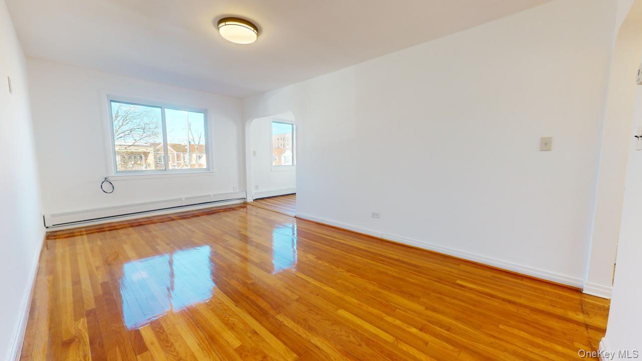 105-28 63rd Road, Unit 2 Queens, NY 11375 - Photo 3 of 30 an empty room with wooden floor and windows
