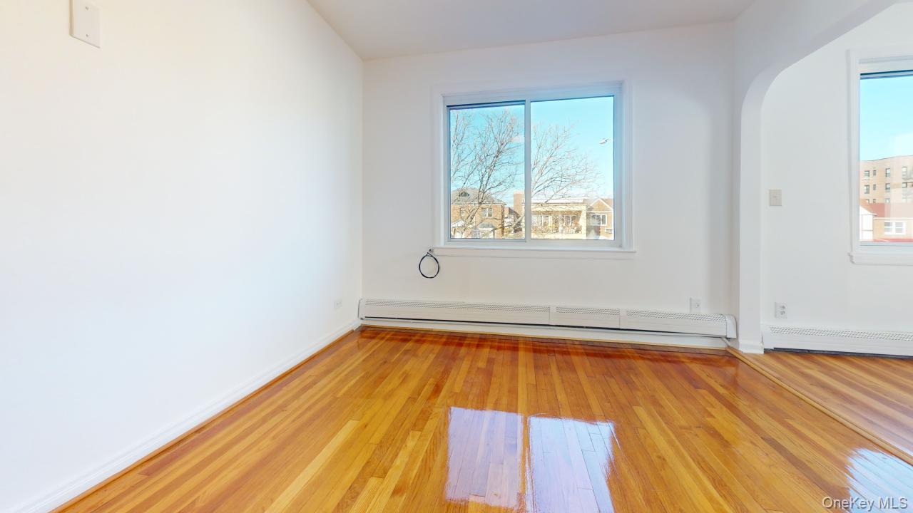 105-28 63rd Road, Unit 2 Queens, NY 11375 - Photo 4 of 30 an empty room with wooden floor and windows