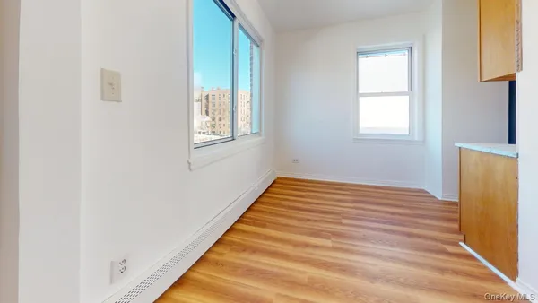 a view of empty room with window and wooden floor