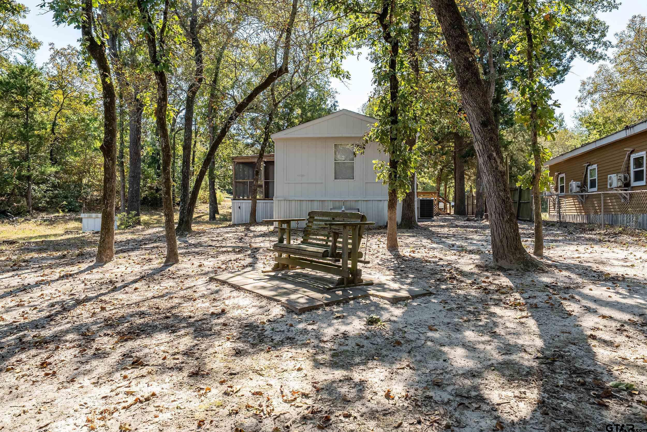 125 Ridgewood Lane Murchison, TX 75778 - Photo 32 of 46 a backyard of a house with barbeque oven and trees