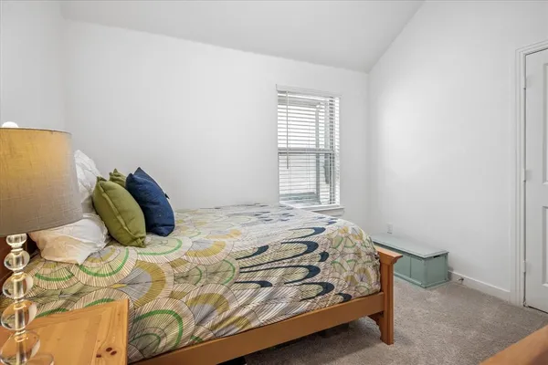 a bed sitting in a bedroom next to a window
