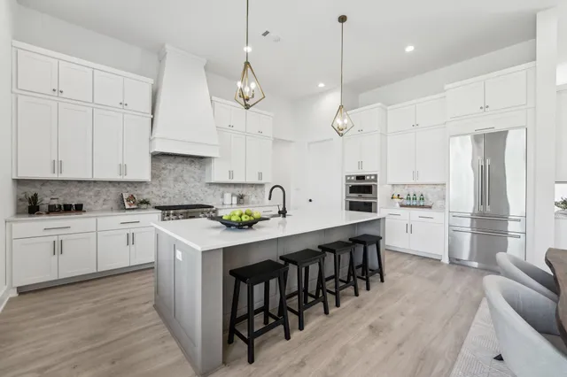 a kitchen with stainless steel appliances granite countertop a stove a sink a center island and cabinets