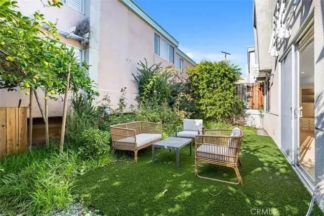a view of a chair and table in backyard of the house