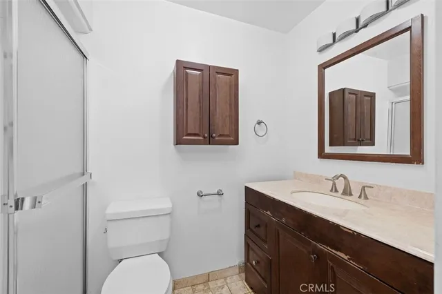 a bathroom with a granite countertop toilet sink and mirror