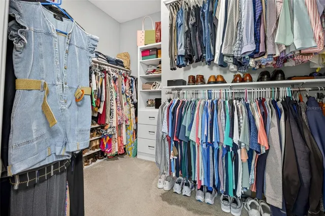 a view of walk in closet with clothes