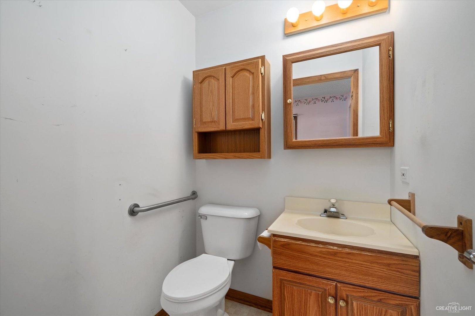 28W678 Warrenville Road Warrenville, IL 60555 - Photo 16 of 21 a bathroom with a toilet sink and mirror