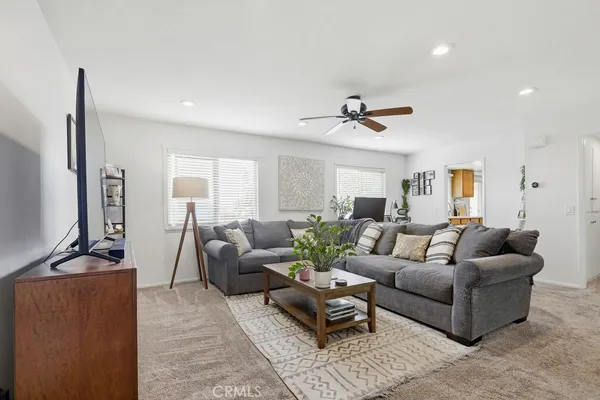 a living room with furniture a ceiling fan and a rug