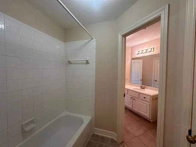 a bathroom with a bathtub sink and mirror