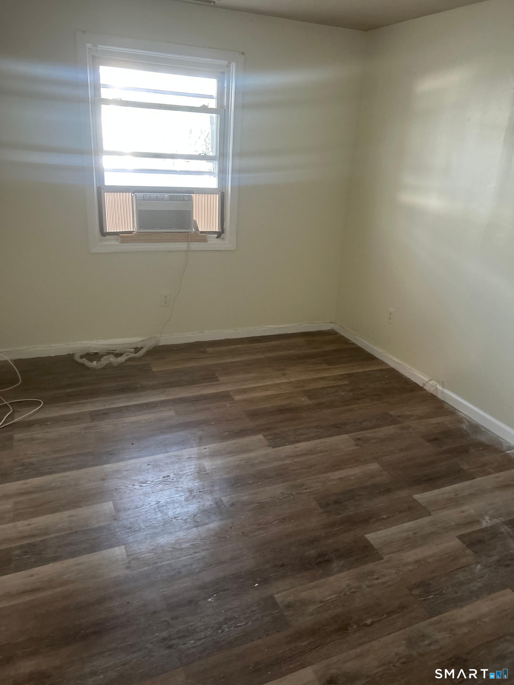 30 Stevens Street, Unit 105 Bridgeport, CT 06606 - Photo 6 of 8 a view of empty room with wooden floor and fan