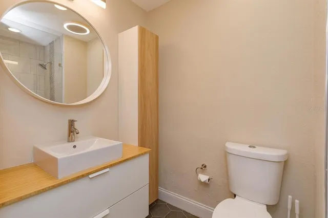 a bathroom with a toilet a sink and mirror