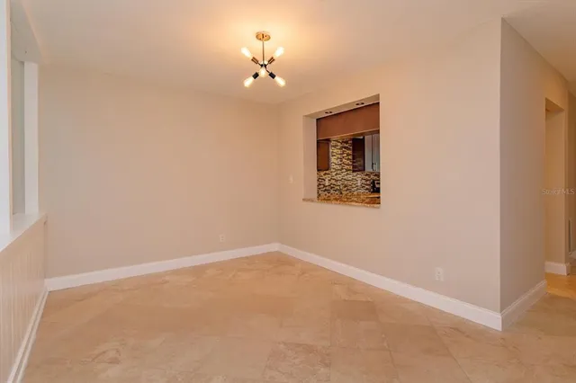 an empty room with a chandelier fan