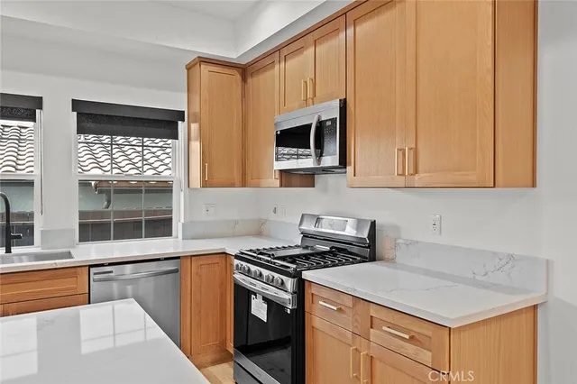 a kitchen with stainless steel appliances granite countertop a sink a stove and a microwave
