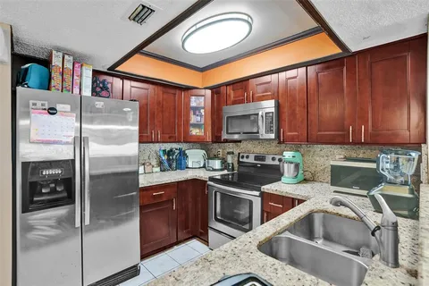 a kitchen with stainless steel appliances granite countertop a refrigerator and a sink
