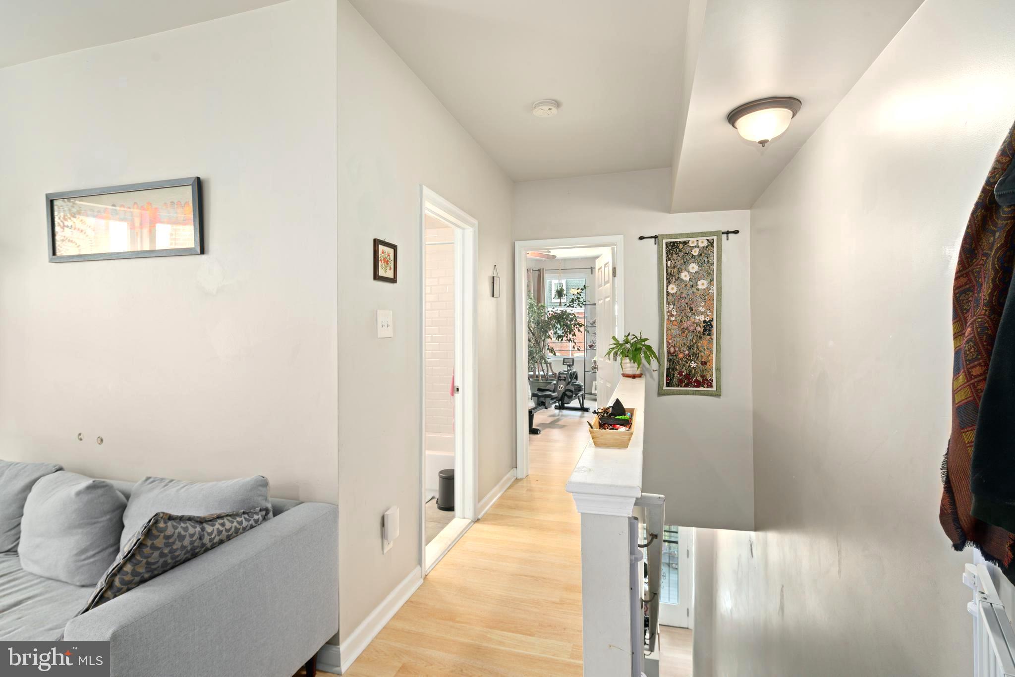 4804 Kingsessing Avenue Philadelphia, PA 19143 - Photo 13 of 17 a hallway with furniture and a wooden floor