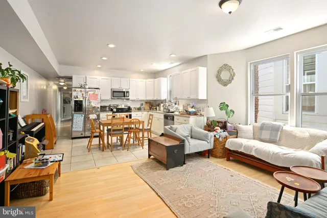 a living room with lots of furniture and a large window