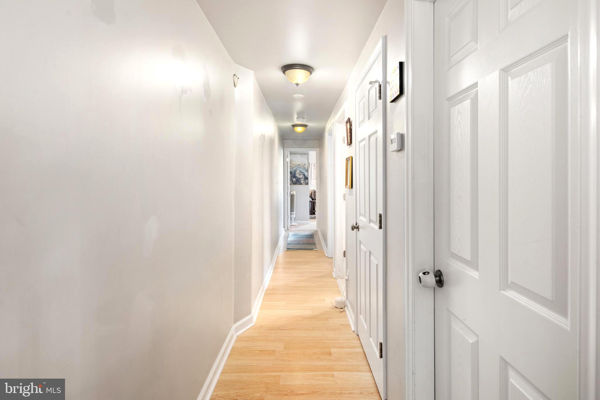 4804 Kingsessing Avenue Philadelphia, PA 19143 - Photo 9 of 17 a view of a hallway with wooden floor and a bathroom