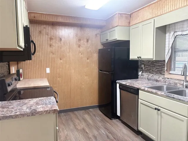 a kitchen with granite countertop a refrigerator and a sink