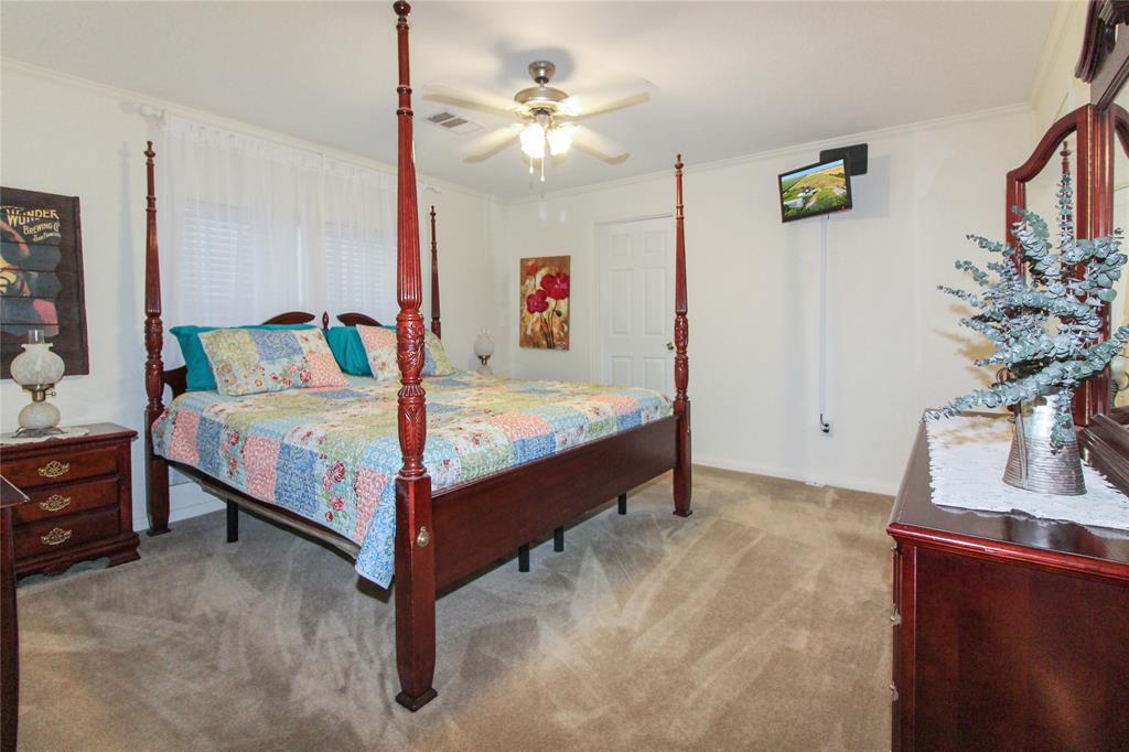 455 Hughes Cemetery Road Italy, TX 76651 - Photo 16 of 40 a bed room with a bed and a chandelier