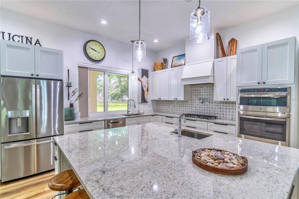 31035 Pasco Road San Antonio, FL 33576 - Photo 17 of 80 a kitchen with a refrigerator a stove a microwave and a counter top space