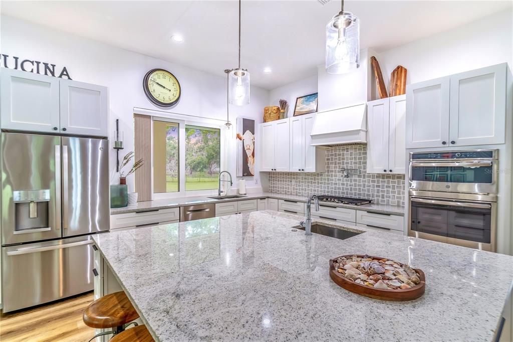 31035 Pasco Road San Antonio, FL 33576 - Photo 20 of 80 a kitchen with a refrigerator a stove a microwave and a counter top space