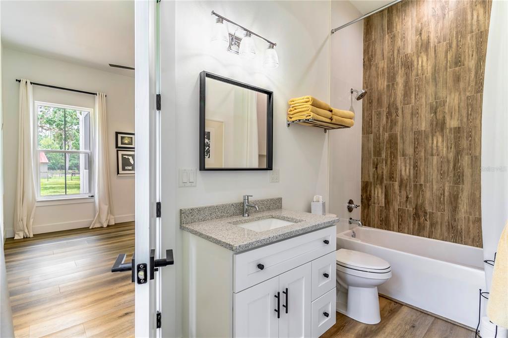 31035 Pasco Road San Antonio, FL 33576 - Photo 34 of 80 a bathroom with a granite countertop sink toilet and shower a mirror