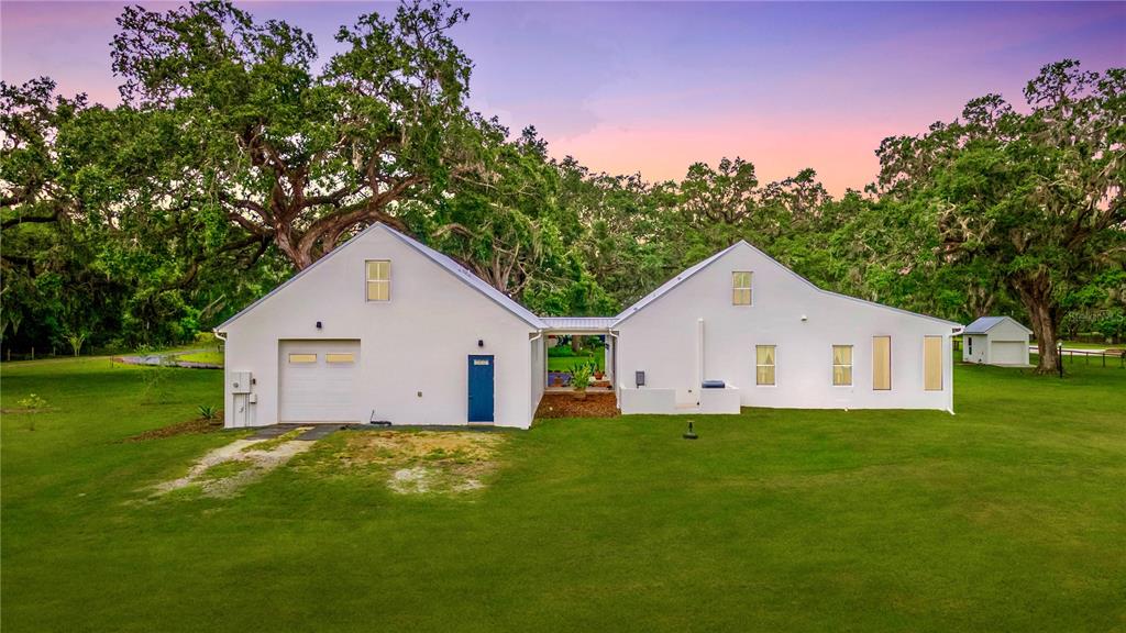 31035 Pasco Road San Antonio, FL 33576 - Photo 66 of 80 a house that is sitting in the grass with large trees and plants