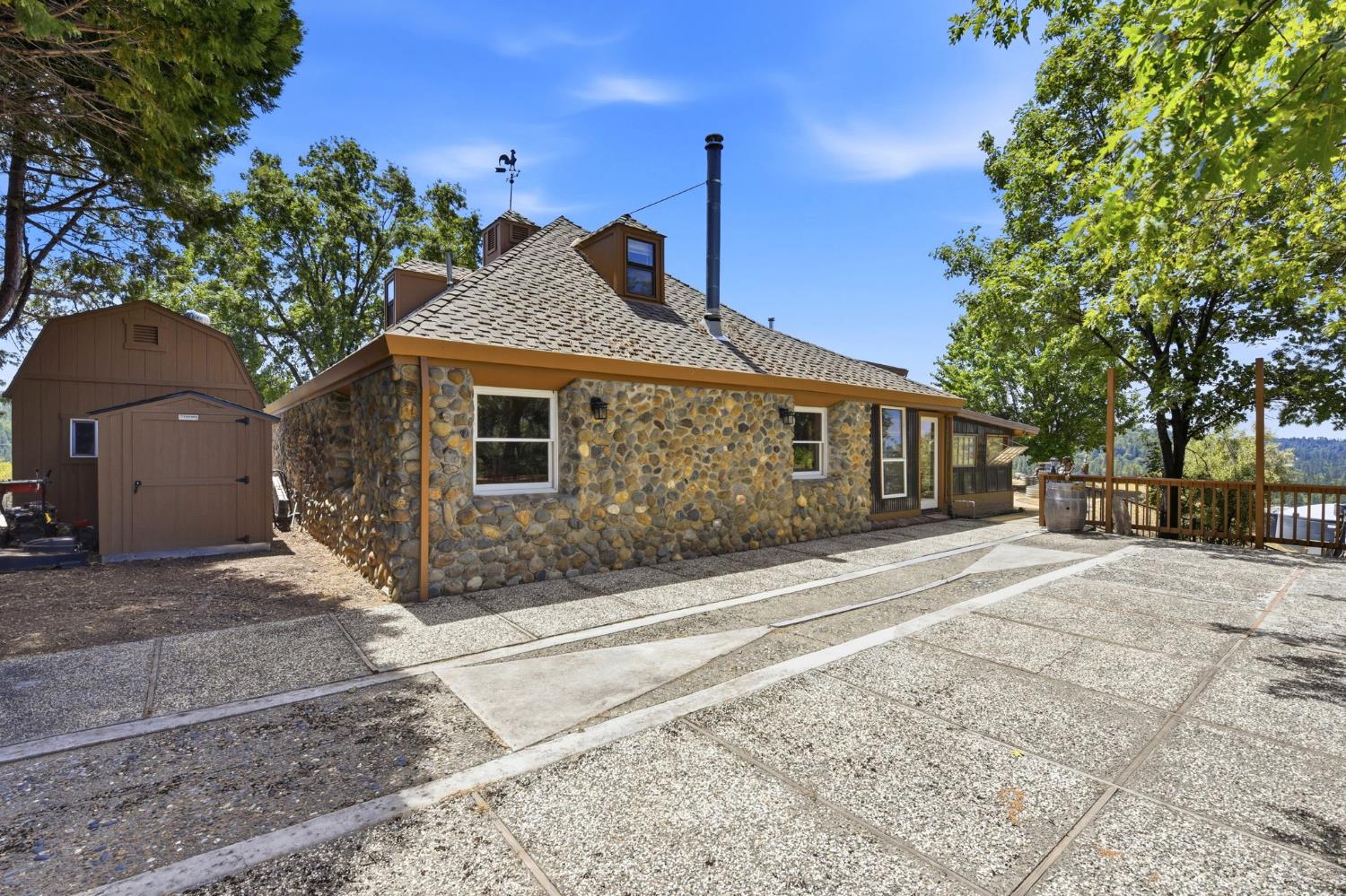 7201 Happy Valley Road Somerset, CA 95684 - Photo 59 of 75 This is a view of the side of the guest cottage. There is also a wood shed and a larger equipment shed next to the garage.