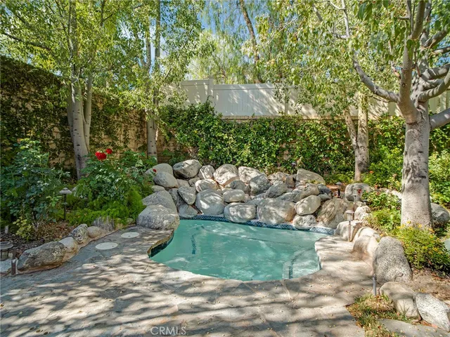a view of a swimming pool with a patio and a yard