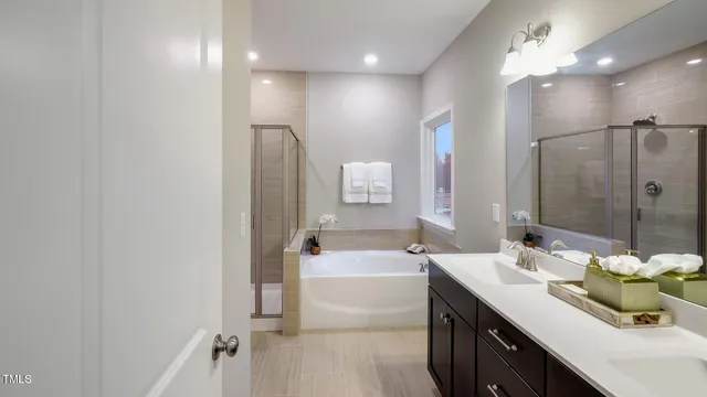 a bathroom with a tub sink and mirror