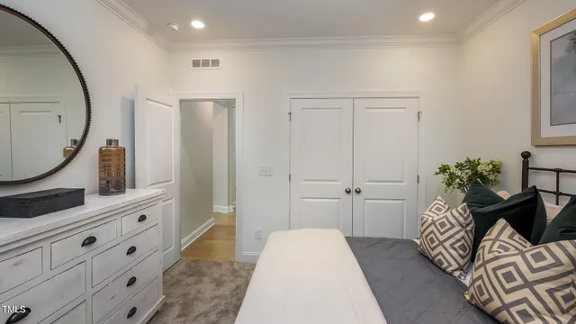 a bedroom with a bed and a mirror on the dresser