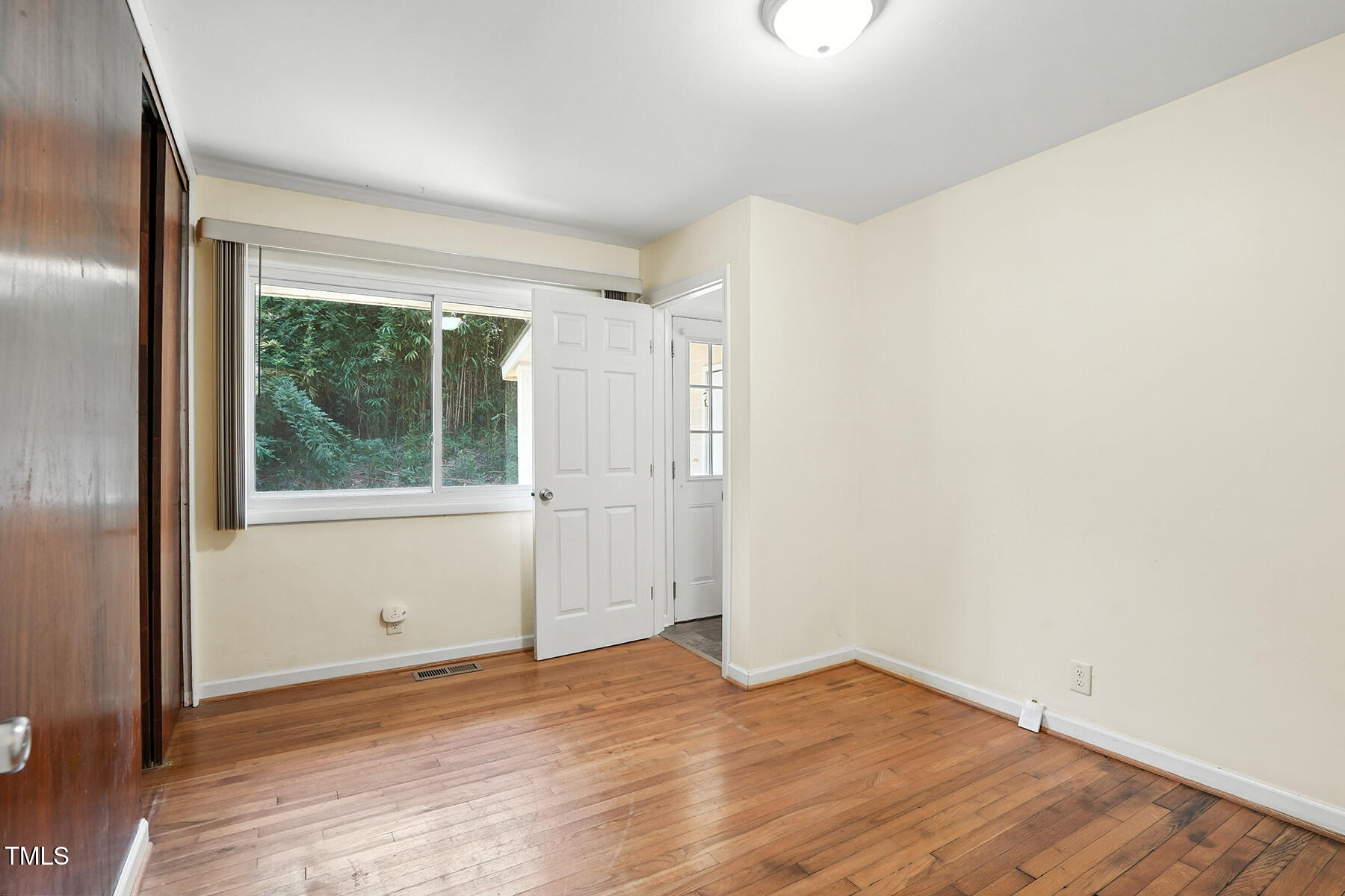 912 Dixie Trail Raleigh, NC 27607 - Photo 14 of 28 an empty room with wooden floor and windows
