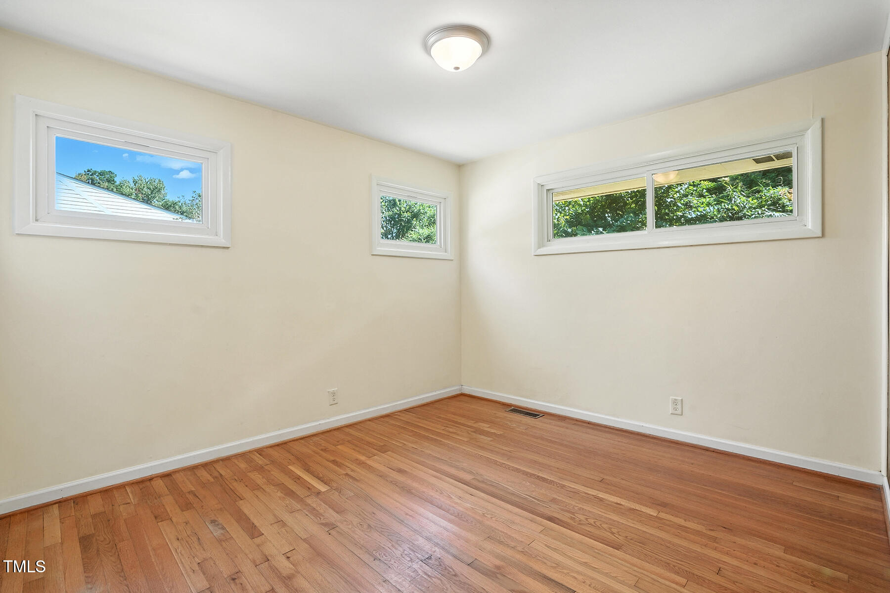 912 Dixie Trail Raleigh, NC 27607 - Photo 18 of 28 wooden floor in an empty room with a window