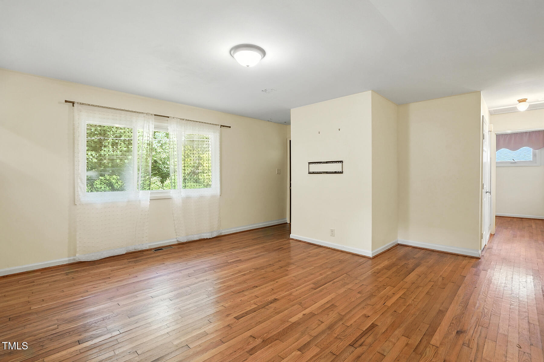 912 Dixie Trail Raleigh, NC 27607 - Photo 7 of 28 an empty room with wooden floor and windows