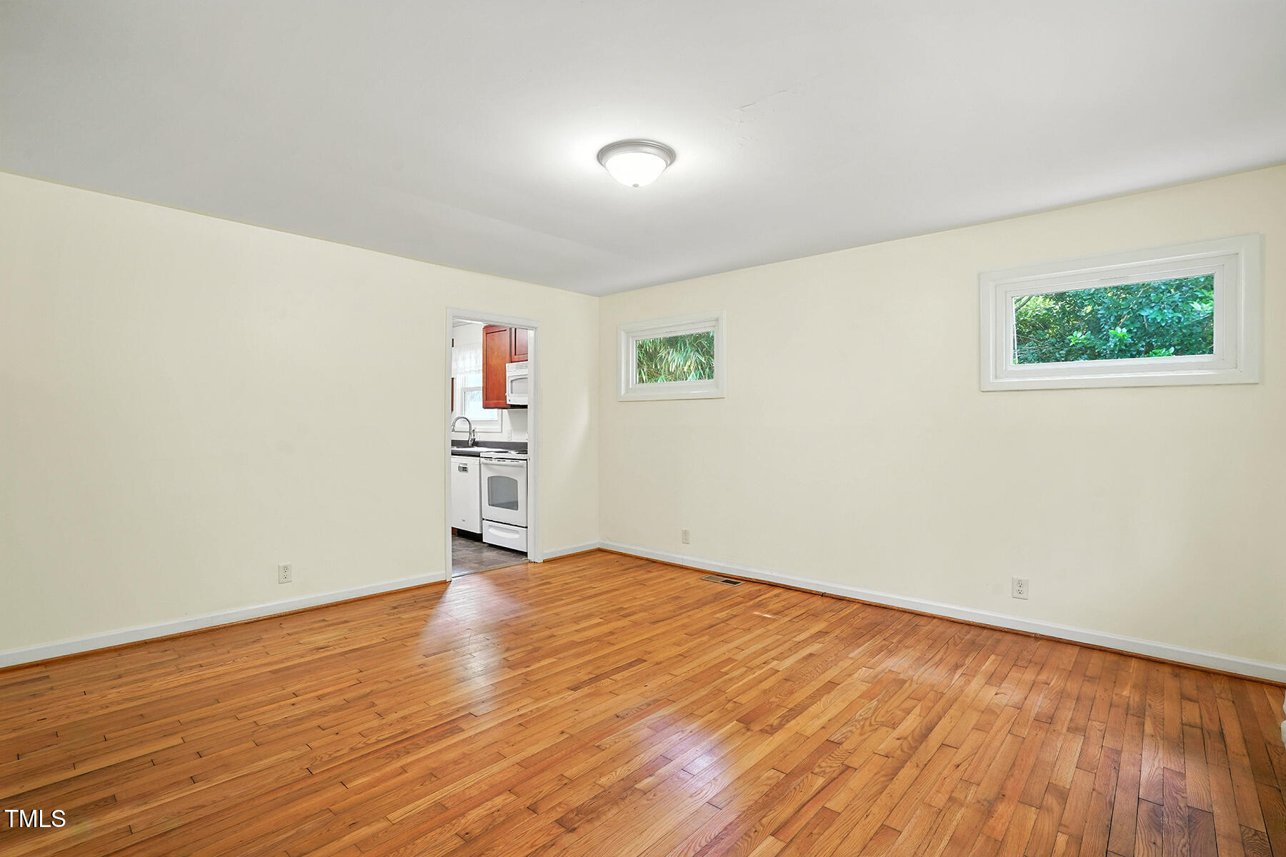 912 Dixie Trail Raleigh, NC 27607 - Photo 8 of 27 an empty room with wooden floor and windows
