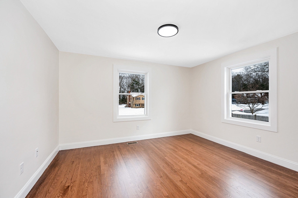 19 Porter Street Billerica, MA 01821 - Photo 17 of 42 an empty room with wooden floor and windows