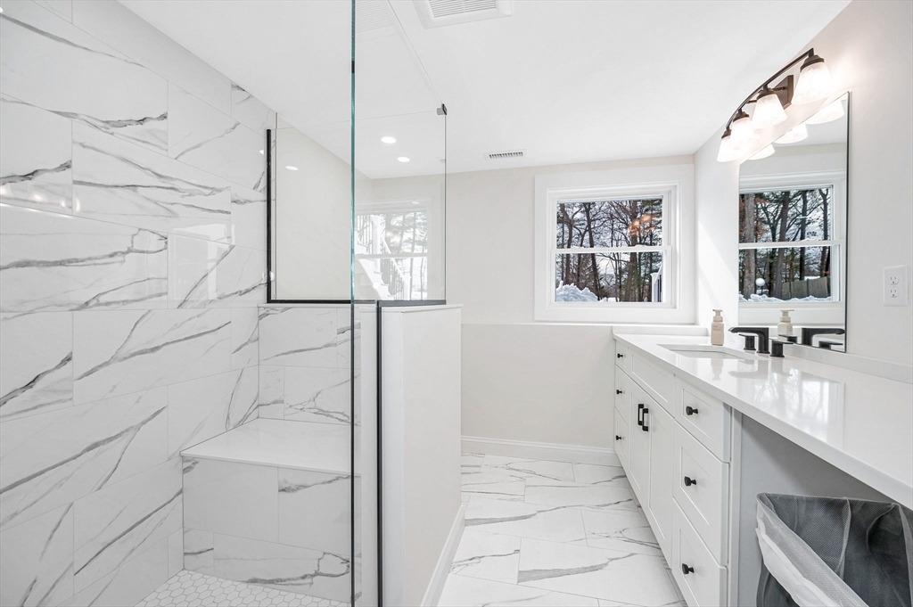 19 Porter Street Billerica, MA 01821 - Photo 29 of 42 a bathroom with a double vanity sink a toilet a mirror and shower